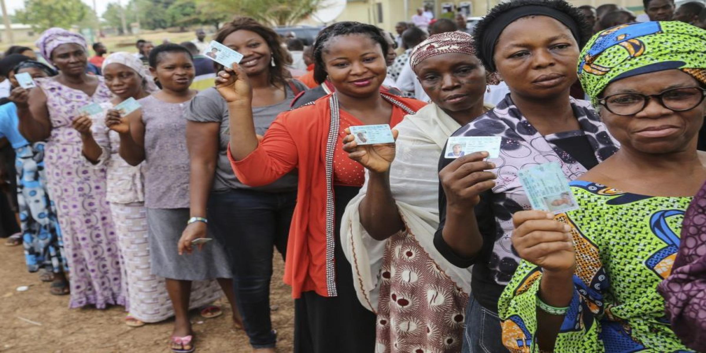 Nigerian voters display their PVCs prior to voting at an election. Nigerians will return to the polls in February 2023. Photo: AFP