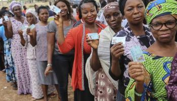 Nigerian voters display their PVCs prior to voting at an election. Nigerians will return to the polls in February 2023. Photo: AFP